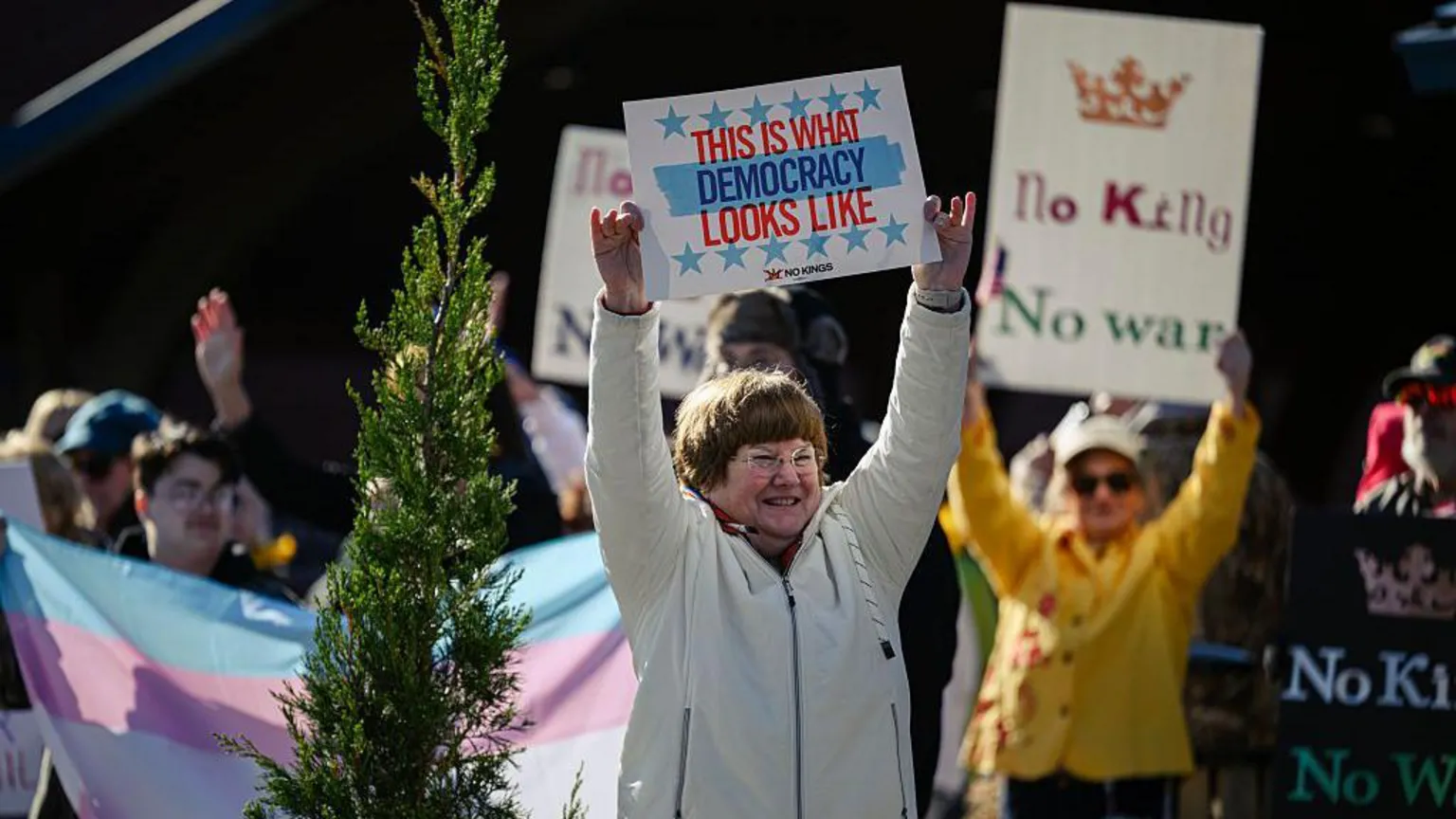  A woman holds a sign reading 