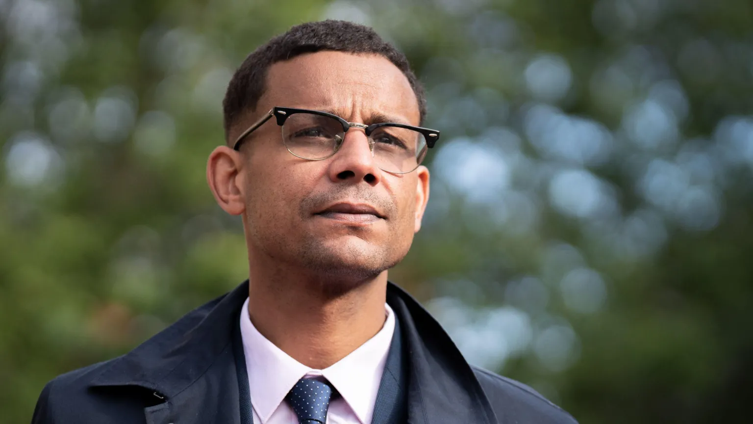 PA Photo of Daniel Kebede. He has short hair and is wearing glasses and a shirt, tie and smart navy blue jacket.