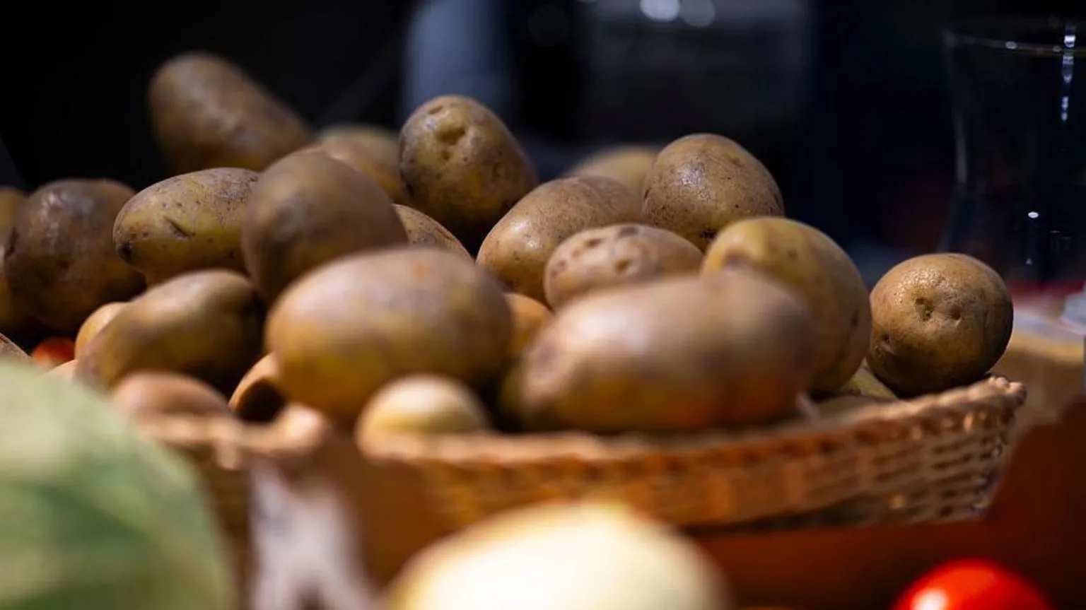 A bowl of potatoes at a market in Germany. The spuds are in focus, the rest of the stall is slightly blurry.