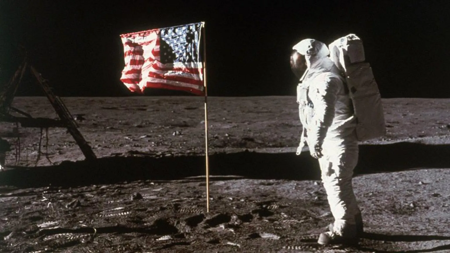 Astronaut Buzz Aldrin stands beside an American flag placed on the moon during Apollo 11 extravehicular activity, 1969