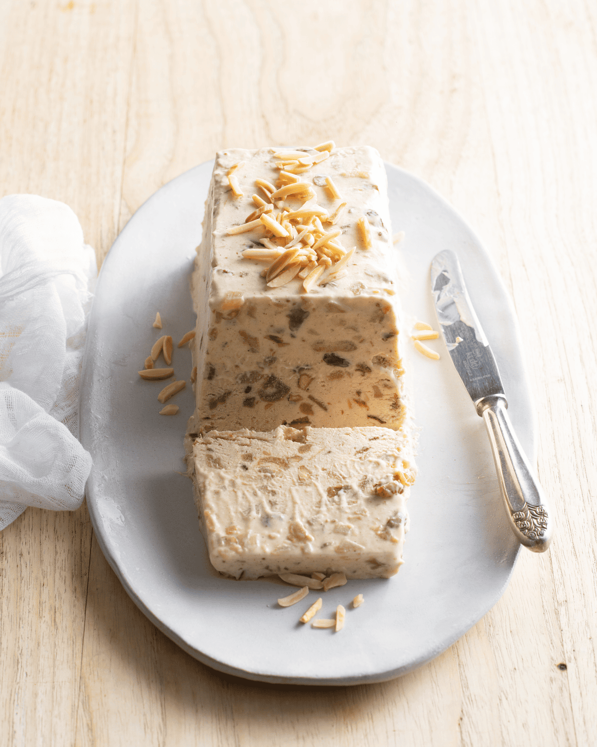 A log of ice-cream partfait, scatted with chopped almonds.