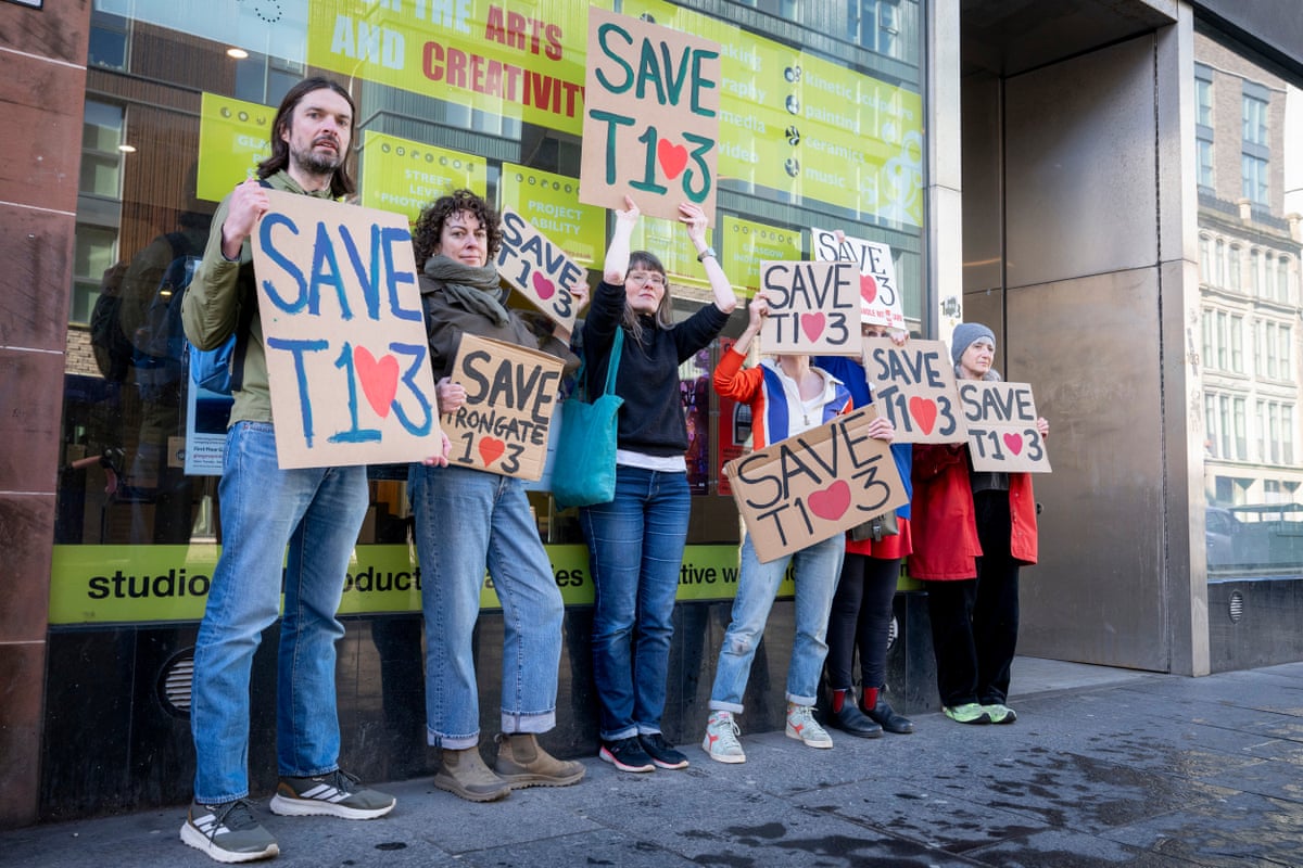 Group of six people holding signs reading: “Save T103” with the zeros made to look like hearts.