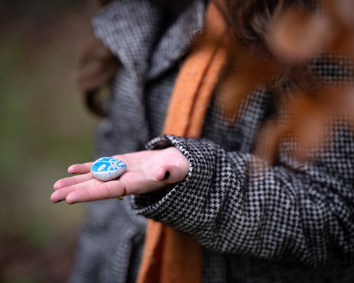 Ella’s hand holding a blue painted stone