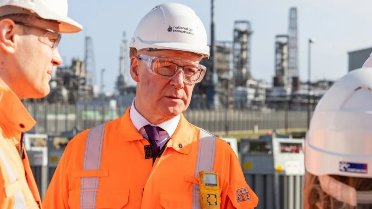  John Swinney in an orange high-visibility jacket and hard hat at an industrial plant 