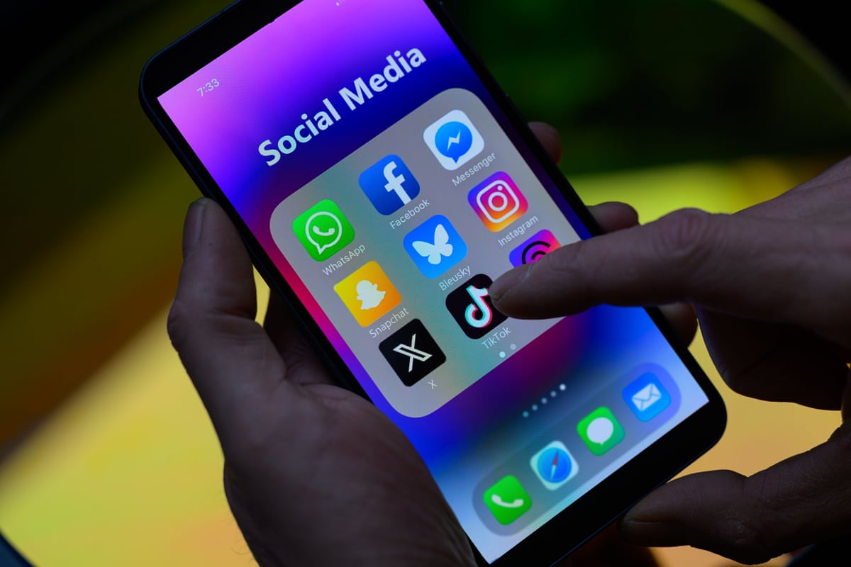 The TikTok icon is seen alongside other apps on a mobile phone.