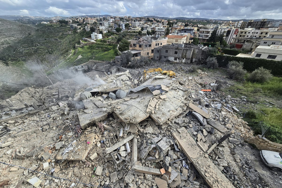 First responders work on the rubble of a building targeted by an Israeli airstrike in the southern Lebanese village of Hanouiyeh on 30 March.