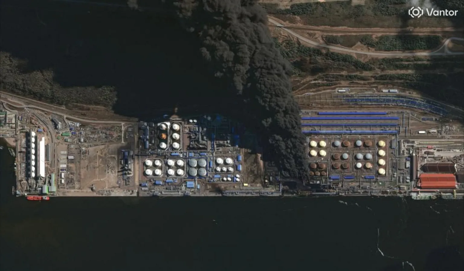Vantor An enormous black smoke cloud coming from a Russian oil storage facility next to the water