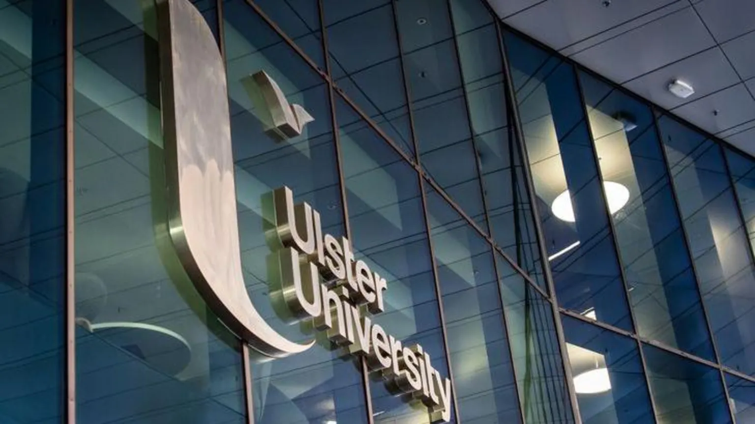 A building with large windows. A sign with the words 'Ulster University' is in the centre of the image.