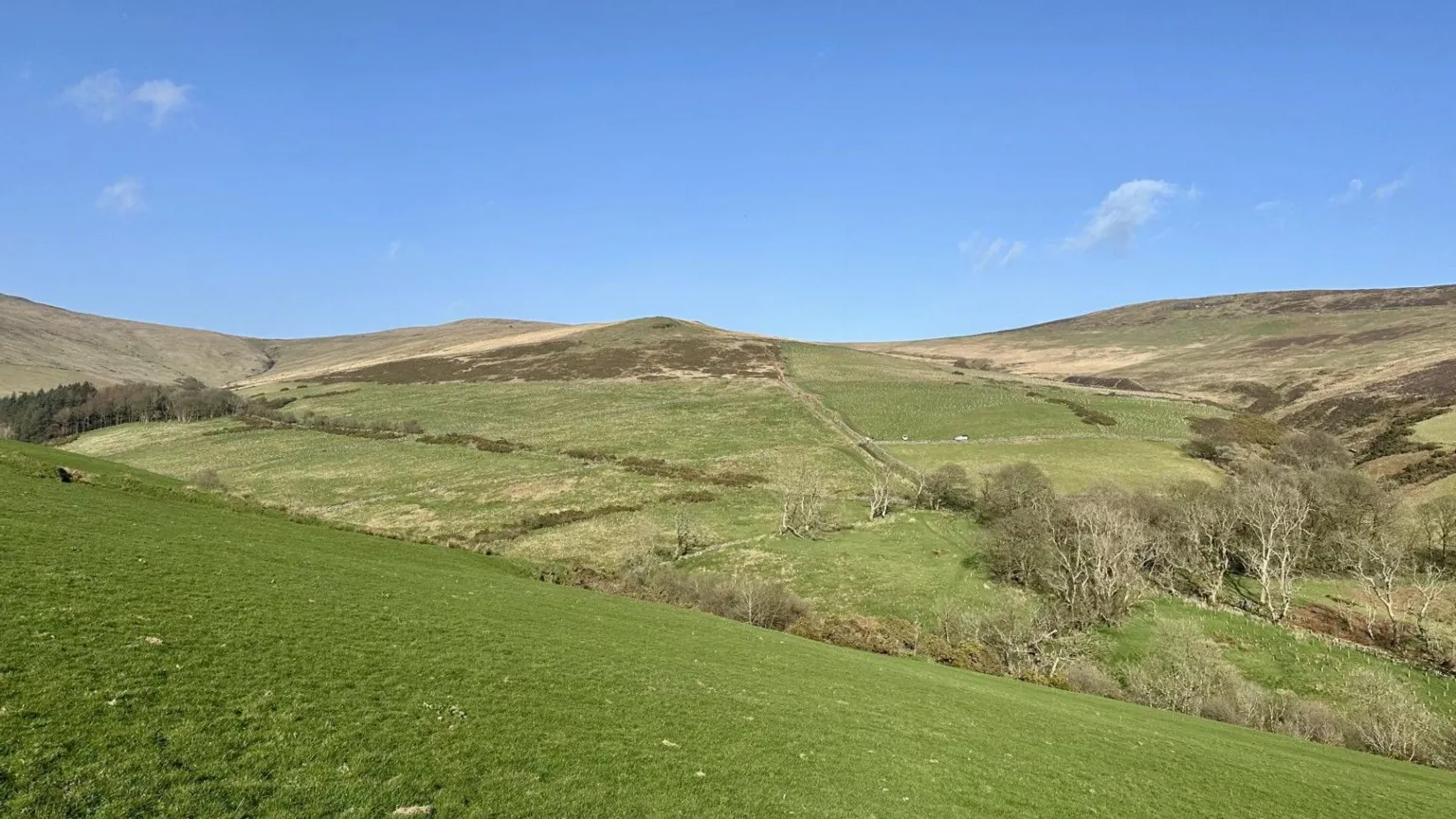 graham makepeace-warne Shot of Creg y Cowin nature reserve. Rolling green hills are seen. Taken on a blue sky day.