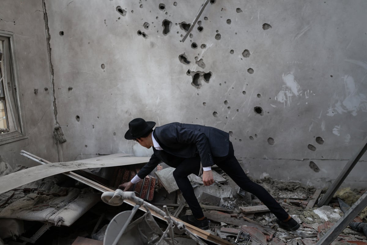 An ultra-Orthodox Jewish man assesses the damage inside a house following an Iranian strike over Bnei Brak in central Israel on 31 March, 2026.