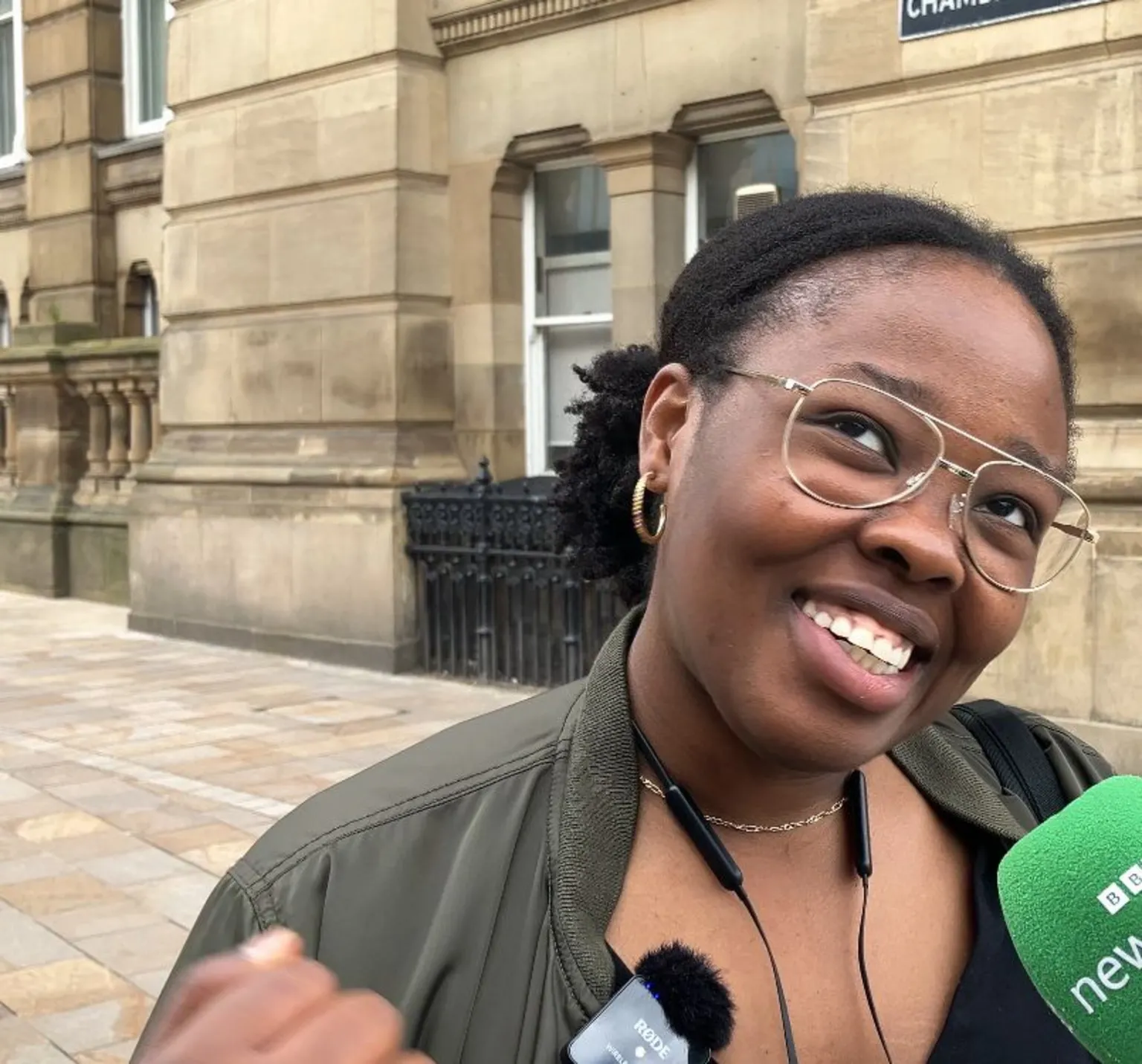 Ifunanya Ezechukwu smiles as she speaks in to a green BBC microphone.