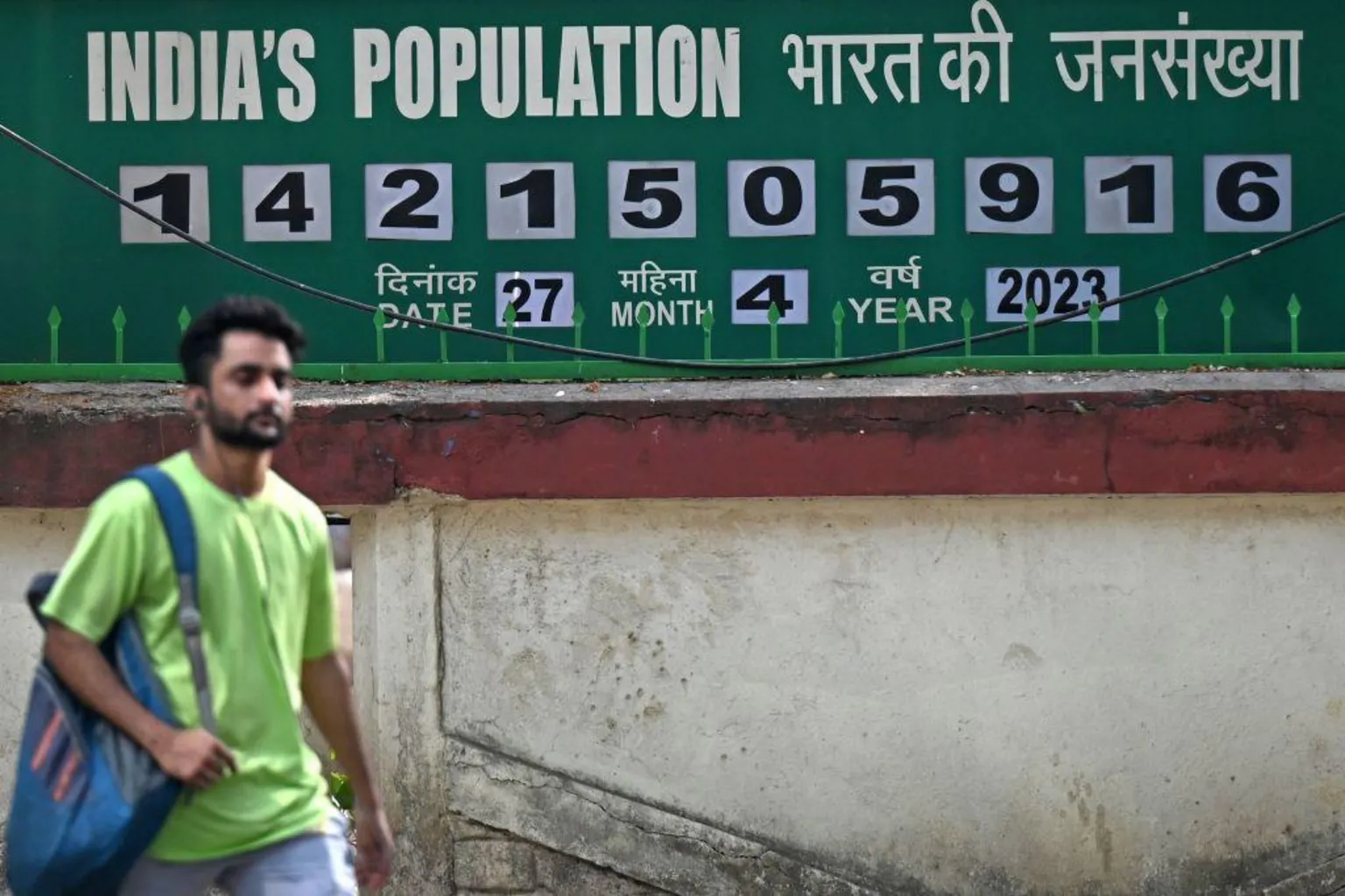 AFP via A pedestrian walks past a population clock board displayed outside the International Institute for Population Sciences (IIPS) in Mumbai.
