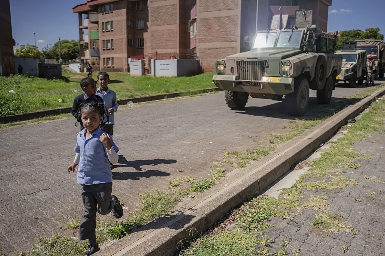 Anadolu via Children in school uniform are seen running in front of an armoured vehicle as soldiers patrol in their neighbourhood