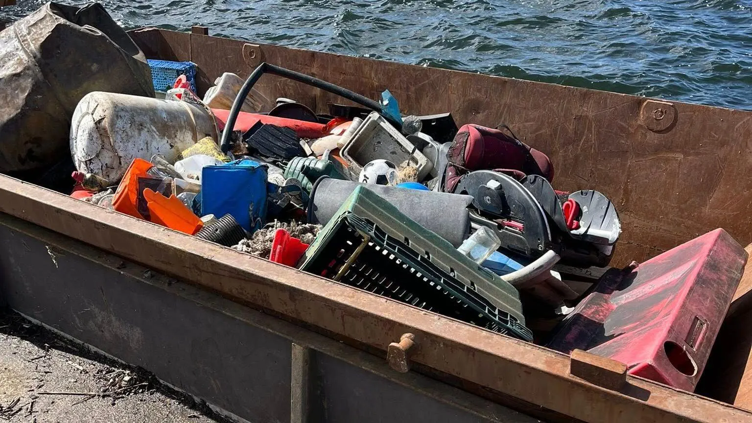 Cardiff Rivers Group A skip full of large discarded items that had been littered at Mermaid Quay in Cardiff Bay. They include a football and childrens car seat.
