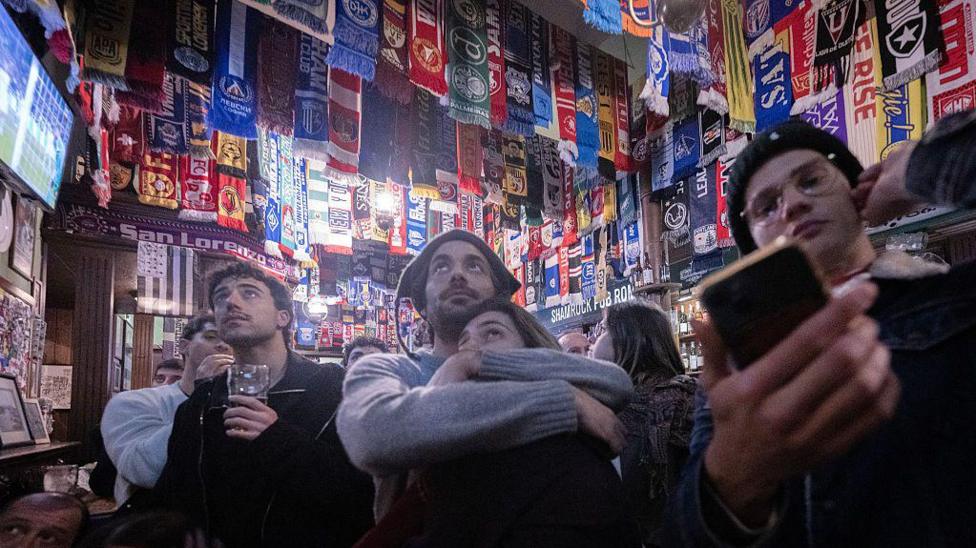 Italy fans watch the football in a pub