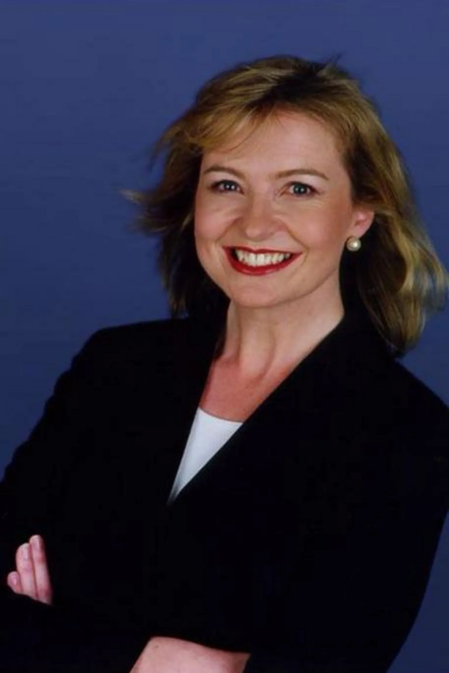 Carol Kirkwood in 2002, smiling with her arms crossed.
