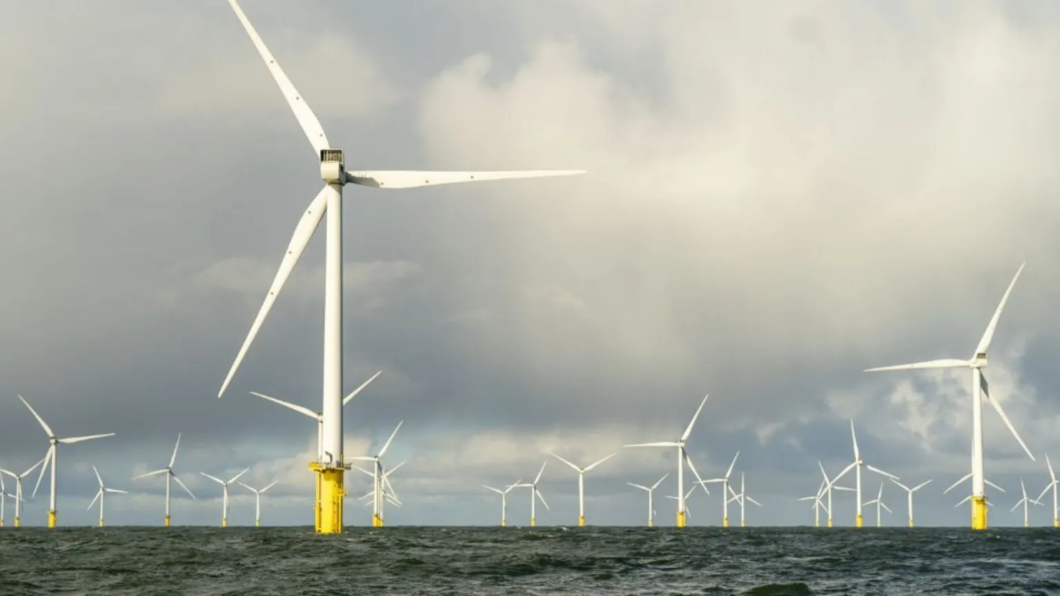  An offshore windfarm set against a cloudy sky