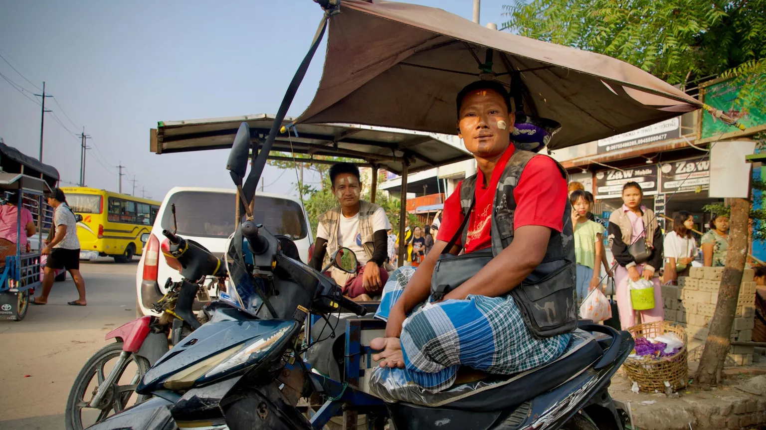 Lulu Luo/ BBC Tin Oo, sitting on the motorbike taxi he drives in Yangon
