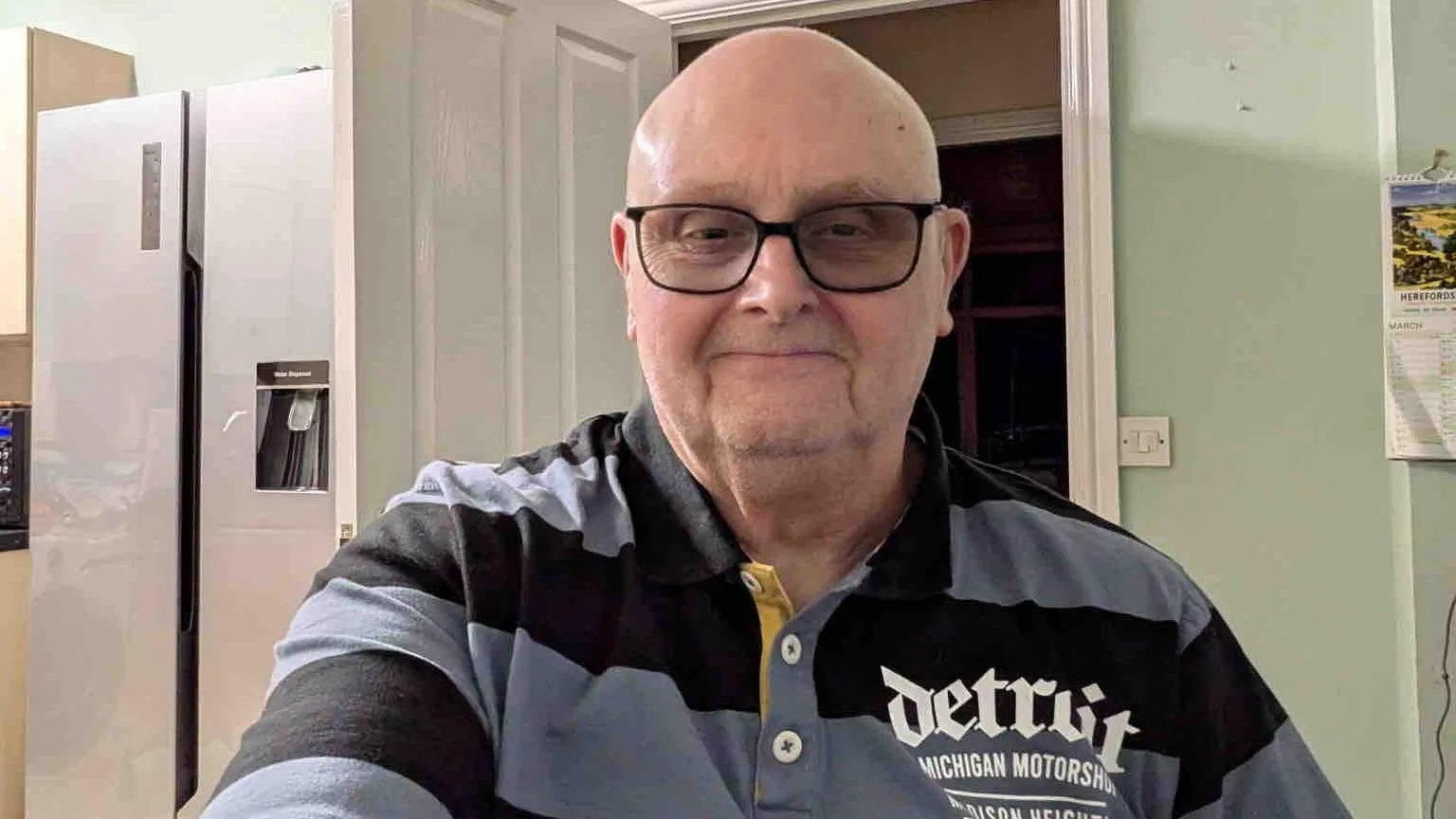 Barry Mackleston Barry takes a selfie wearing varifocal glasses and a striped polo shirt with long sleeves. He is in a kitchen with light green walls.
