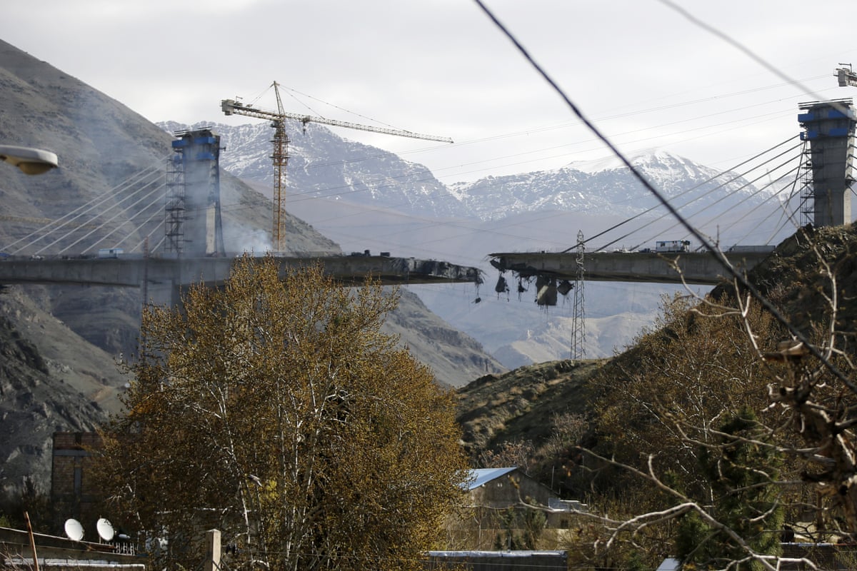A view of a damaged bridge split in half from a bombing.