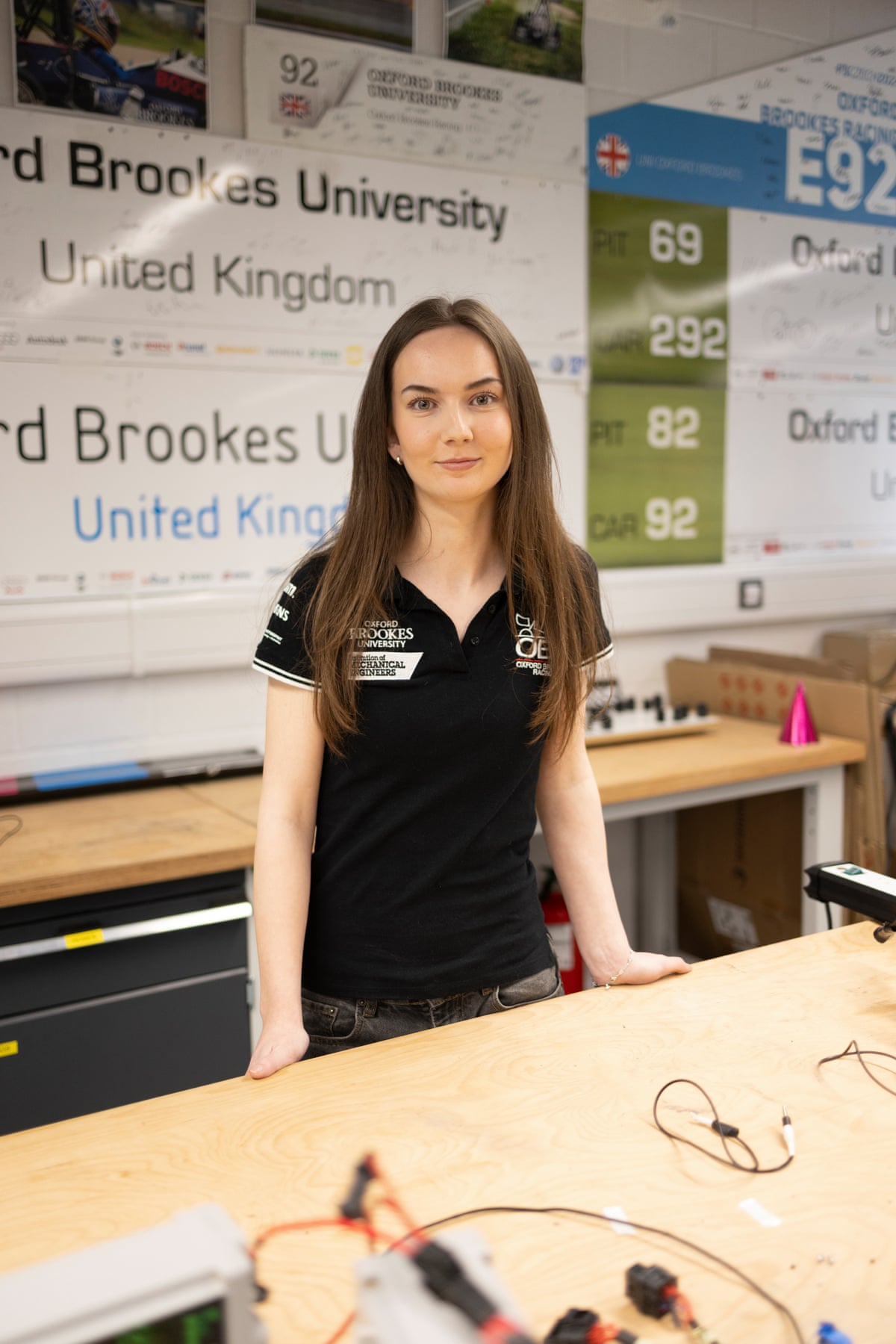 A woman standing behind a desk in a workshop