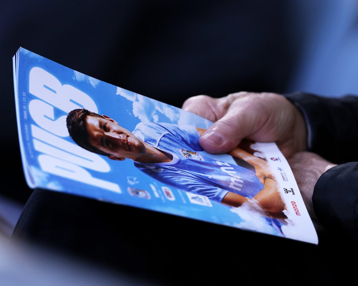 A Coventry City matchday programme is seen being held by a fan prior to the Sky Blues’ Championship match against Derby County.
