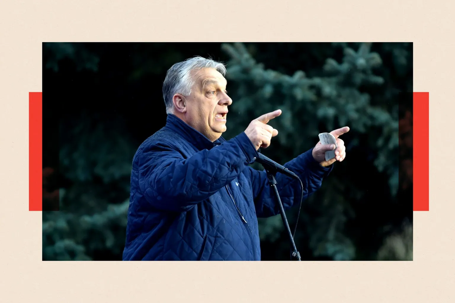 NurPhoto via Orban points while standing in front of a microphone. He wears a dark blue casual jacket 