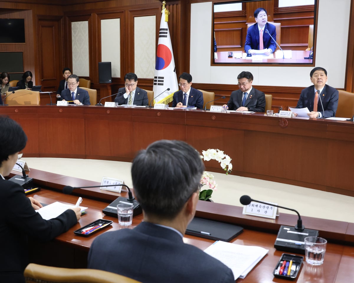 South Korean Finance Minister Koo Yun-cheol (R) attends an emergency meeting of economic ministers at the government complex in Seoul, South Korea, on Friday.