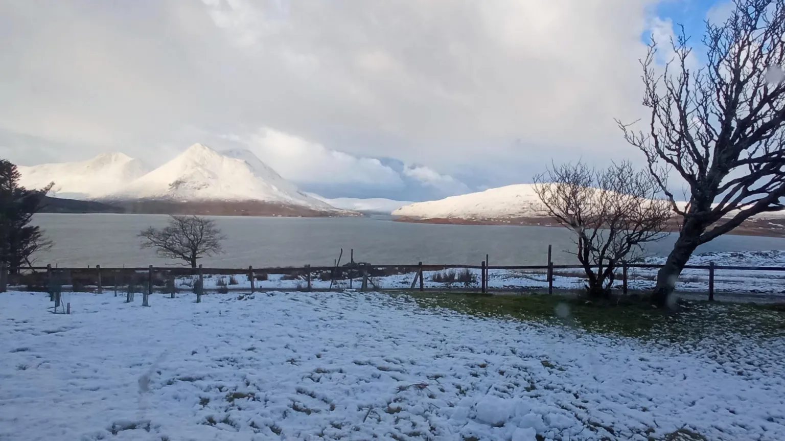 BBC Weather Watchers/Archie MacPhie Snow lies on a field with a lake and snowy hills in the background
