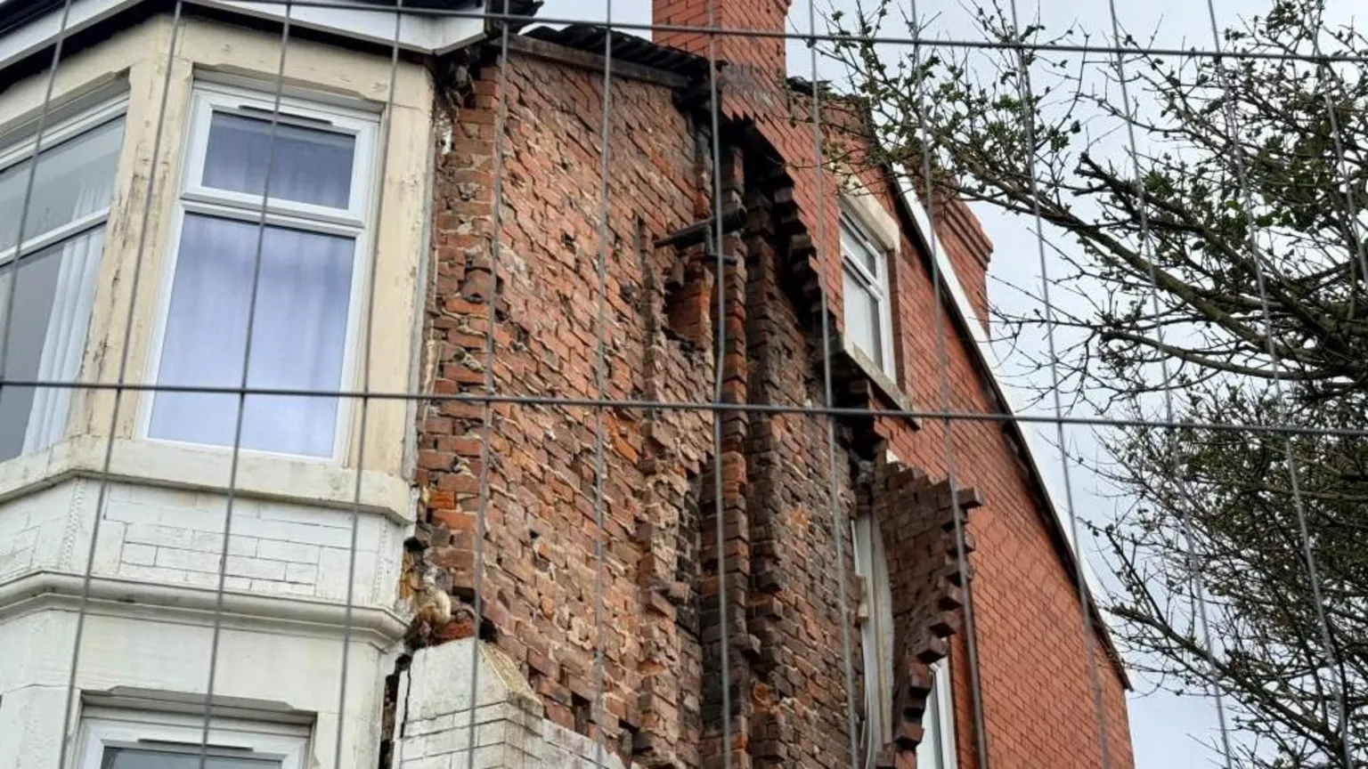 Bricks are missing and a hole in the wall has been left after the gable end of the top floor of a house collapsed.