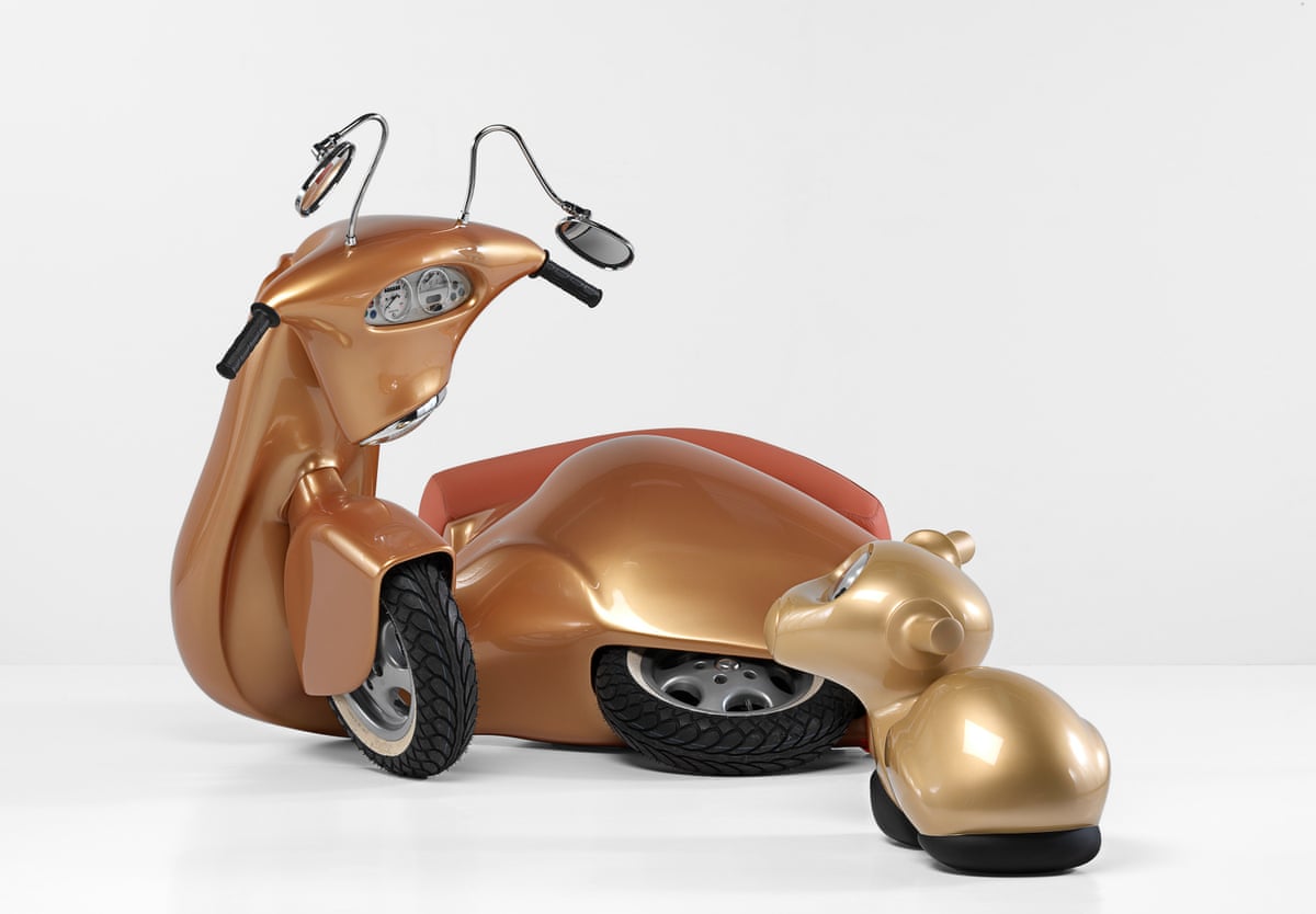 A bronze scooter on its side with a small gold creature beside it