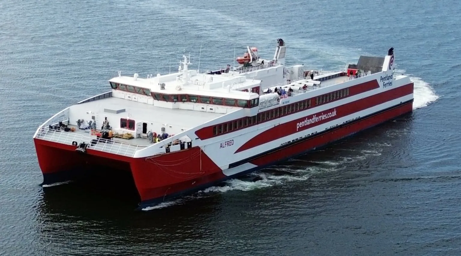 Christopher Brindle A red and white catamaran ferry with Pentland Ferries and written on the side