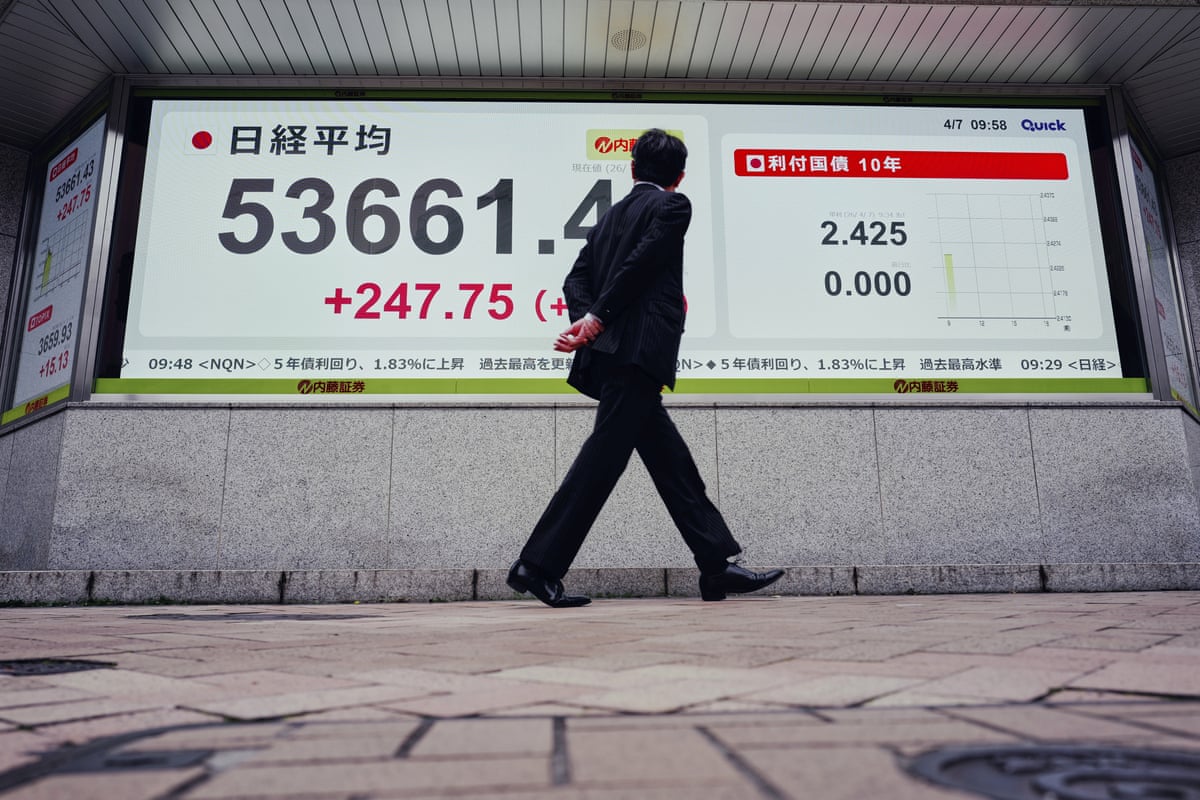 A person looks at an electronic stock board showing Japan's Nikkei index at a securities firm.
