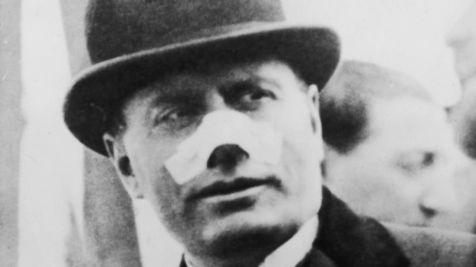  Italian Premier Benito Mussolini (1883 - 1945) leaving for Tripoli, 13th May 1926. His nose is bandaged after an assassination attempt on 26th April by Violet Gibson, who shot him with a revolver at close range. 