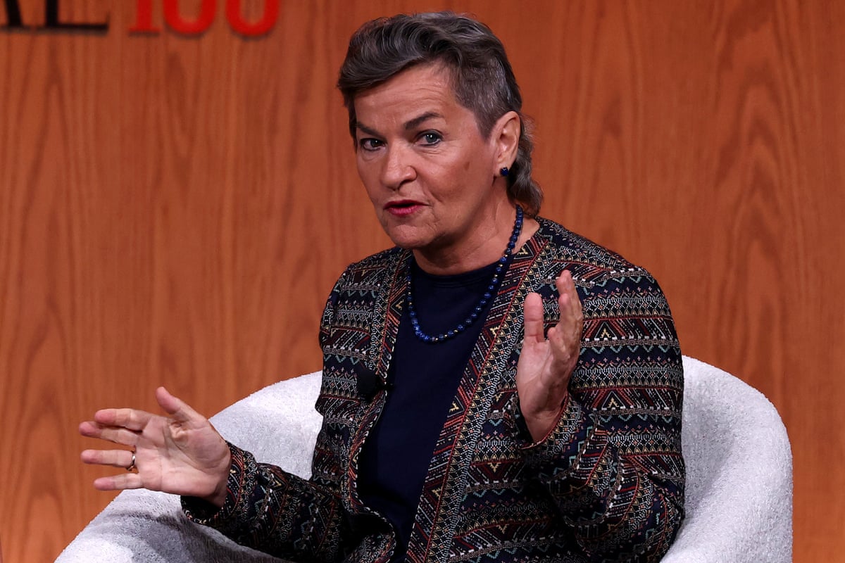 Figueres gestures as she sits on a chair on stage