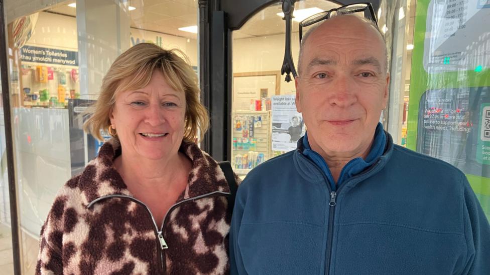 Mary a Martin Williams yn cysgodi rhag y glaw yn Aberteifi 