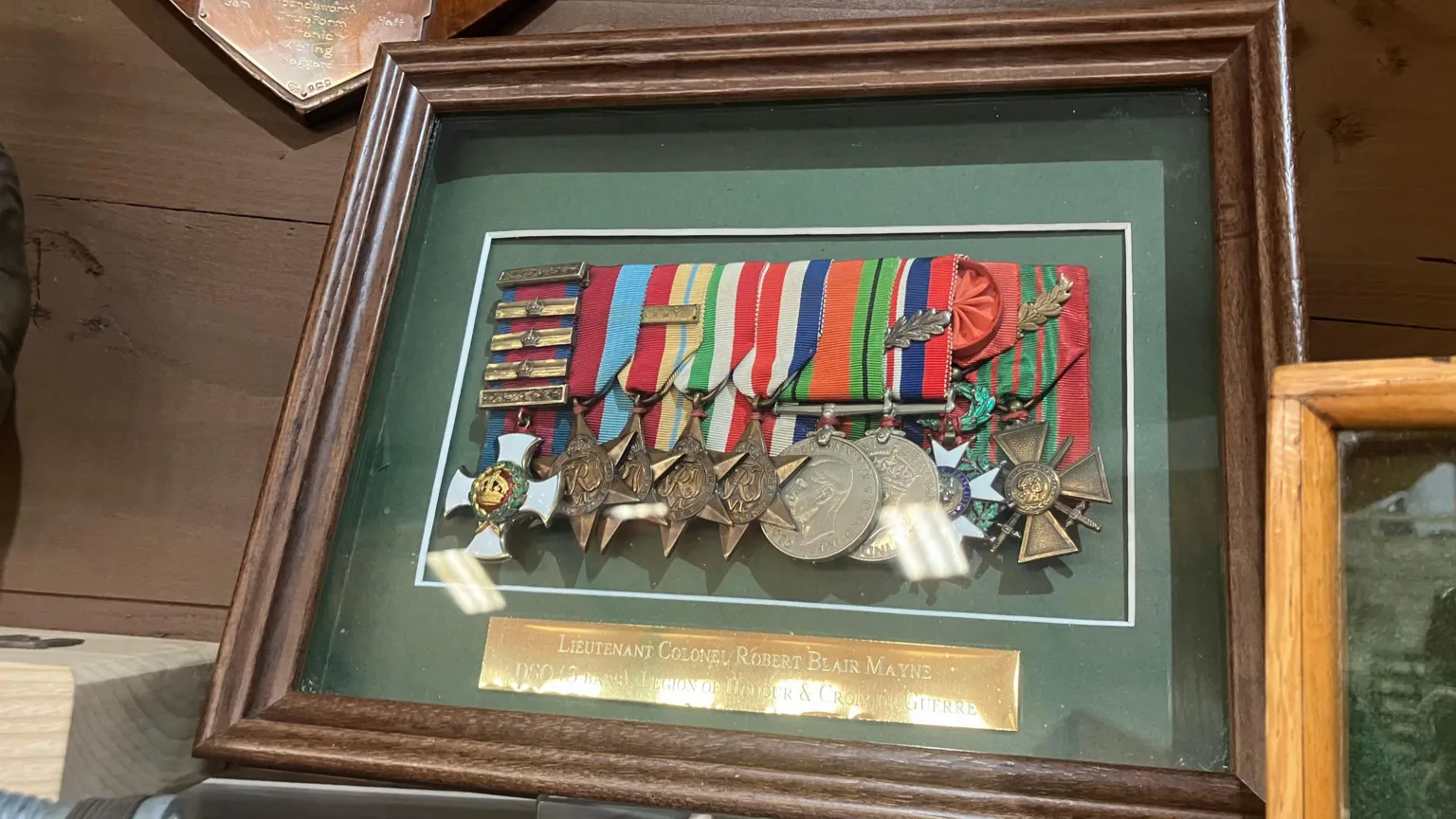 A collection of Blair Mayne's medals. The nine medals are displayed in brown wooden frame behind glass.