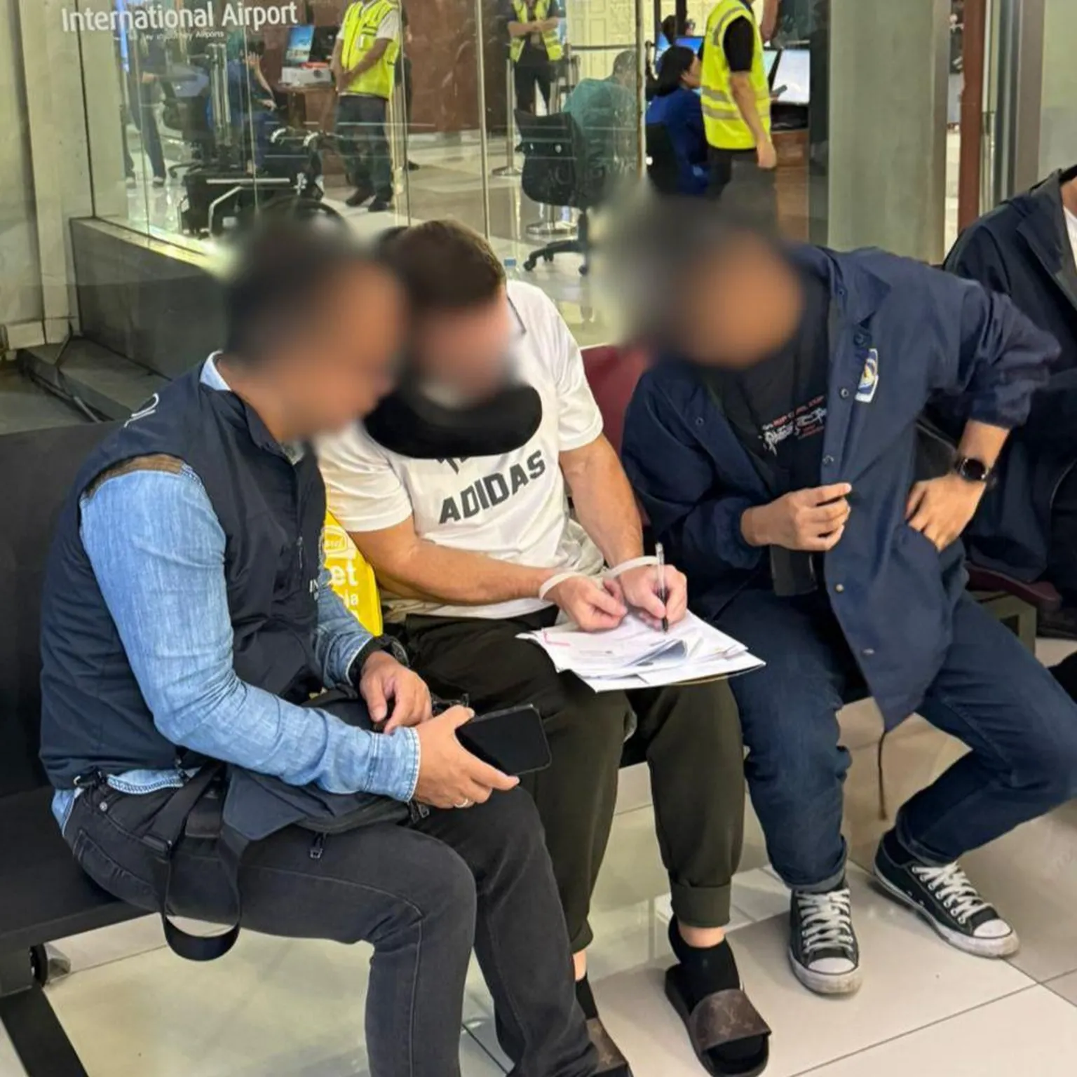 Ngurah Rai Immigration Office Lyons (centre) was photographed filling out a form at Soekarno–Hatta International Airport in Jakarta