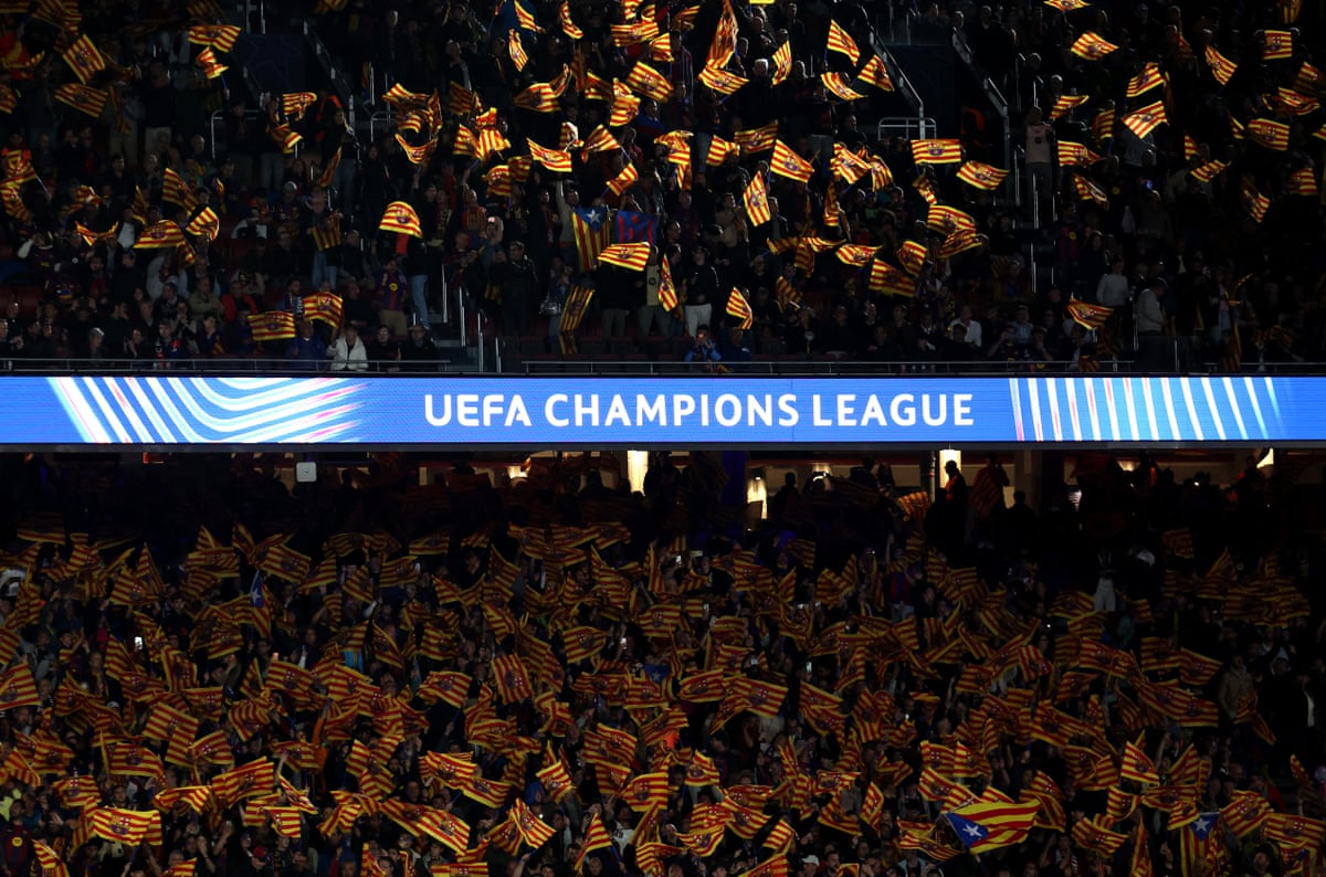 Barcelona fans inside the stadium wave flags.