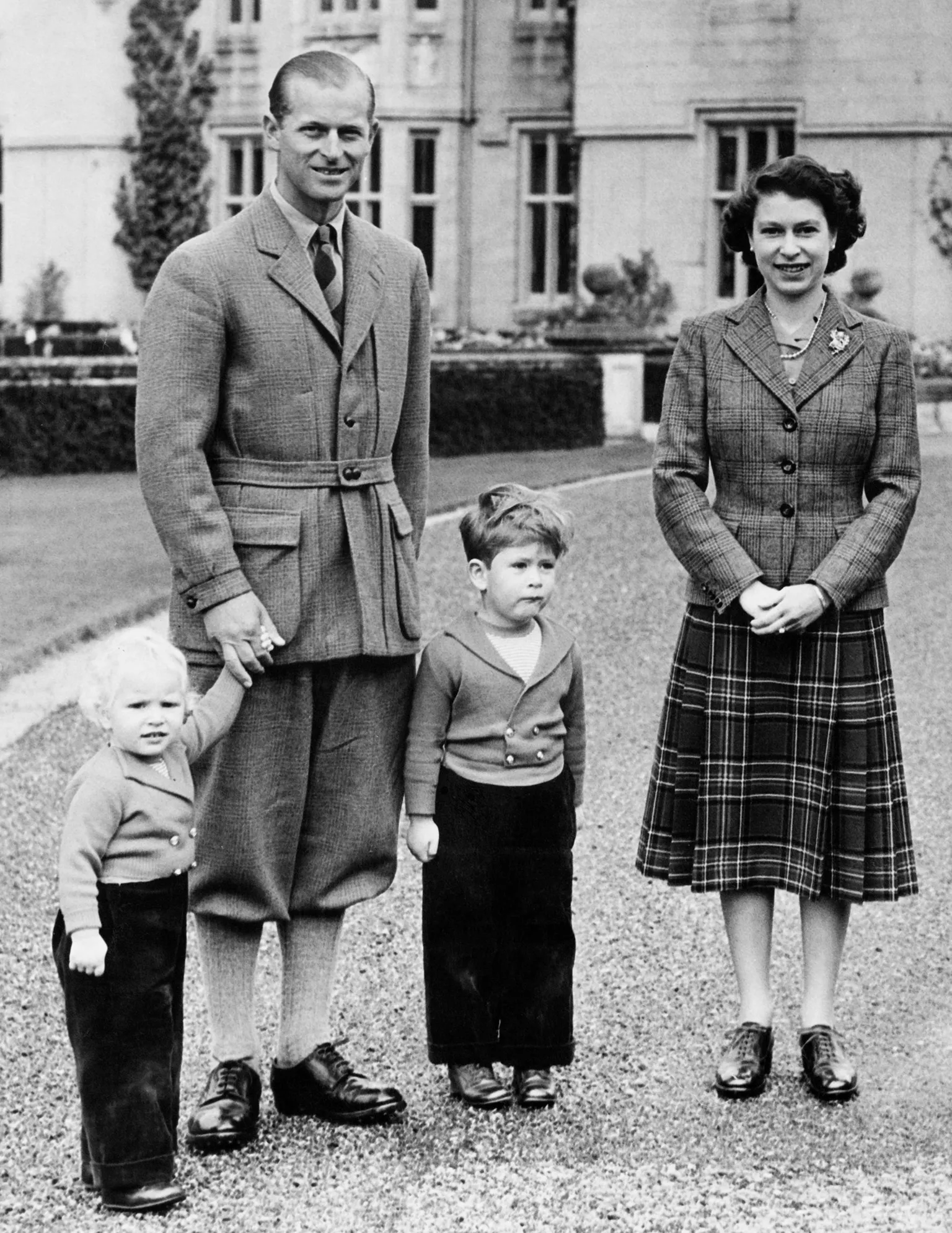 Topical Press Agency / Hulton Archive via The young Queen wearing a different checked tweed blazer and darker tartan knee-length skirt, with the Duke of Edinburgh, Prince Charles and Princess Anne at Balmoral Castle