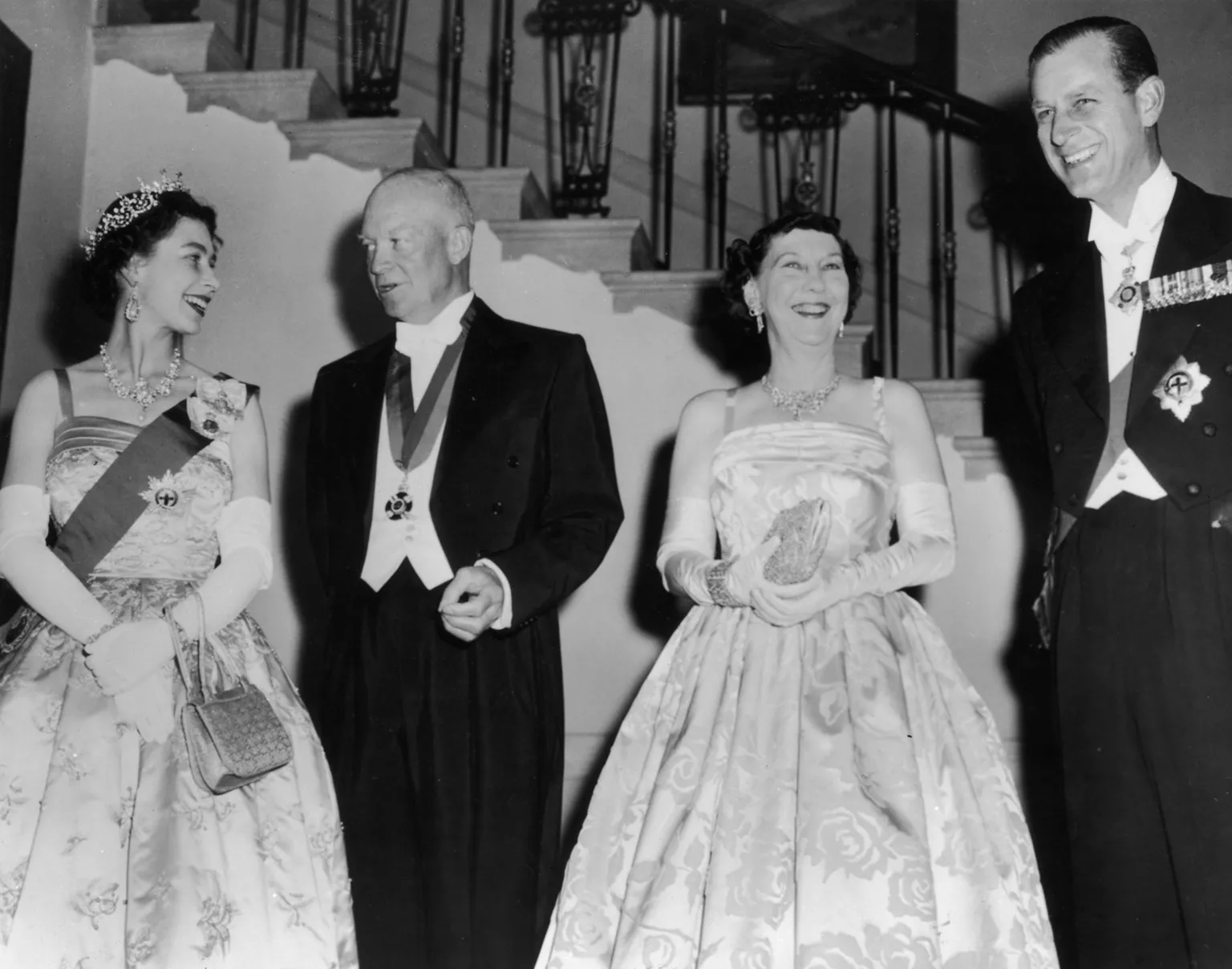 Keystone / The Queen, wearing the apple green dress, a sash and a tiara, is pictured next to Eisenhower, his wife Mamie and Prince Philip in a black and white print.