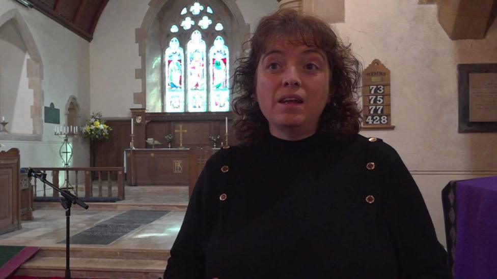 Cyfarwyddwr Cymru Cynghrair Cefn Gwlad, Rachel Evans - menyw gwallt brown ar ei hysgwyddau - yn cael ei holi yn Eglwys Llangadog