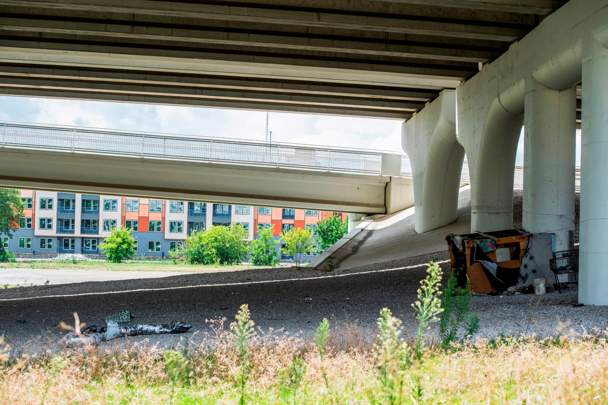 A homeless habitation is seen under a highway overpass