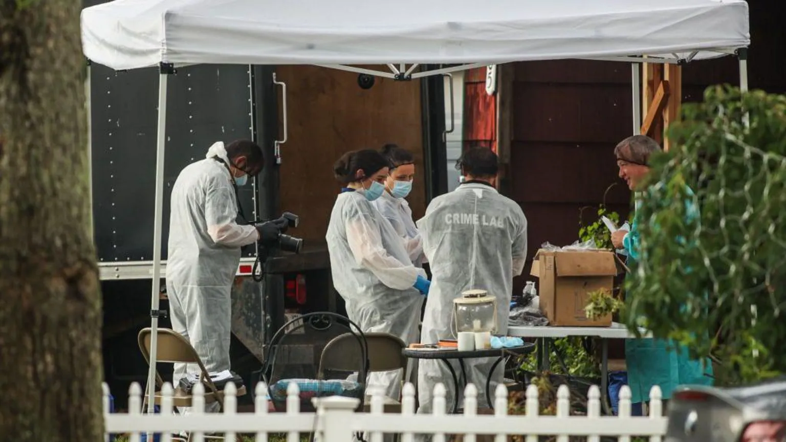  Investigators in white coats, hairnets and jackets labelled 