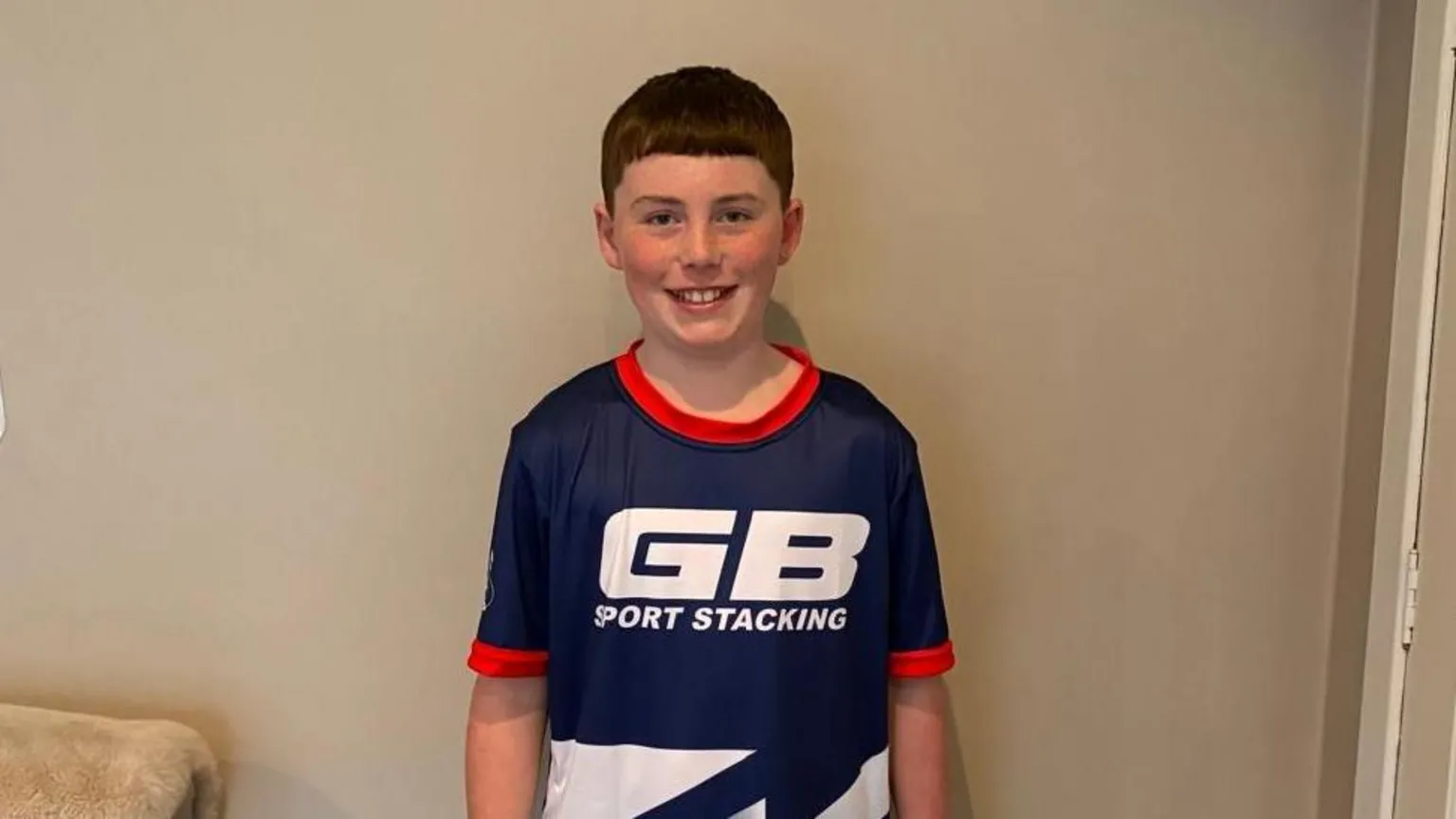 Joanna McStravick Olly is a boy with brown hair and is wearing a blue sports top with 