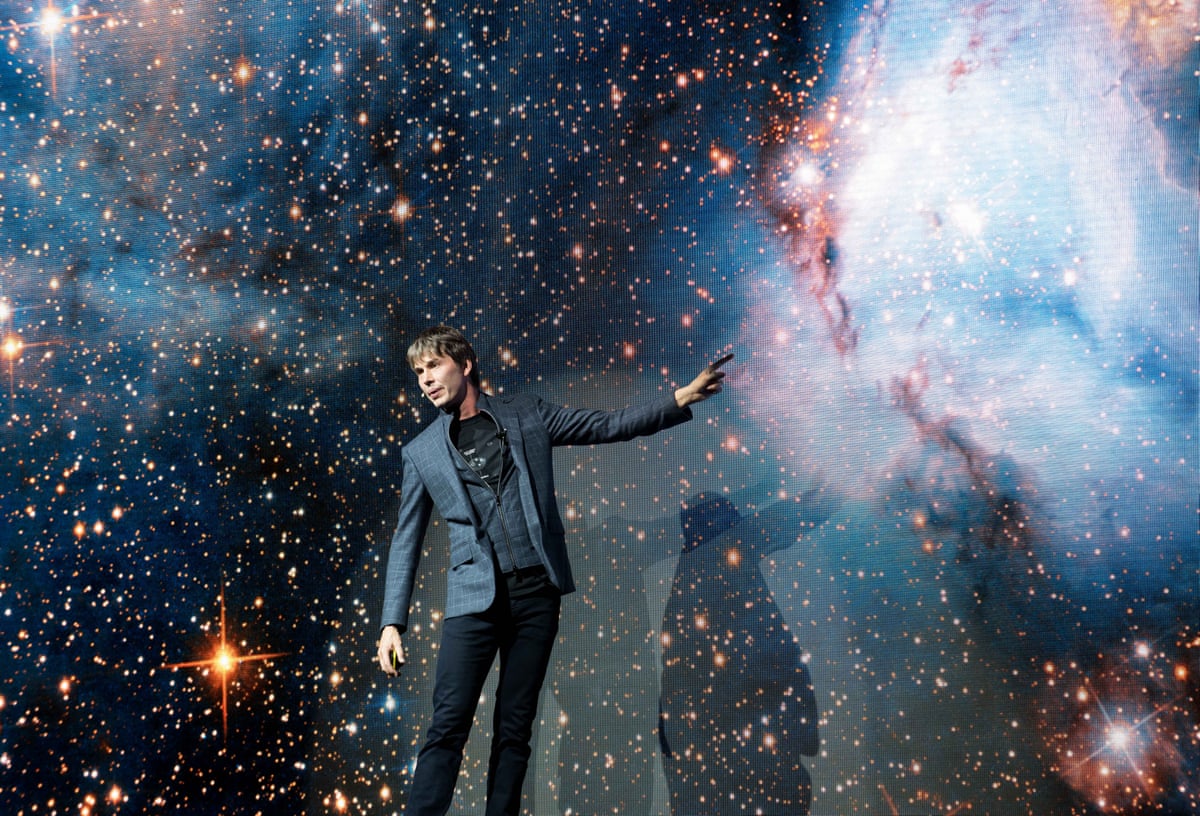 Brian Cox in front of a mural of stars and galaxies