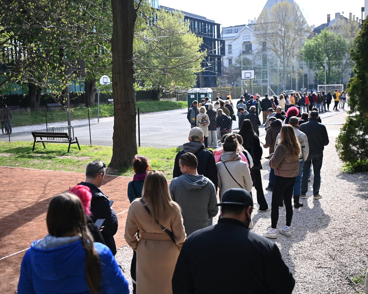 Voters registered outside their home addresses queue in front of a polling station during the general election in Budapest, Hungary.