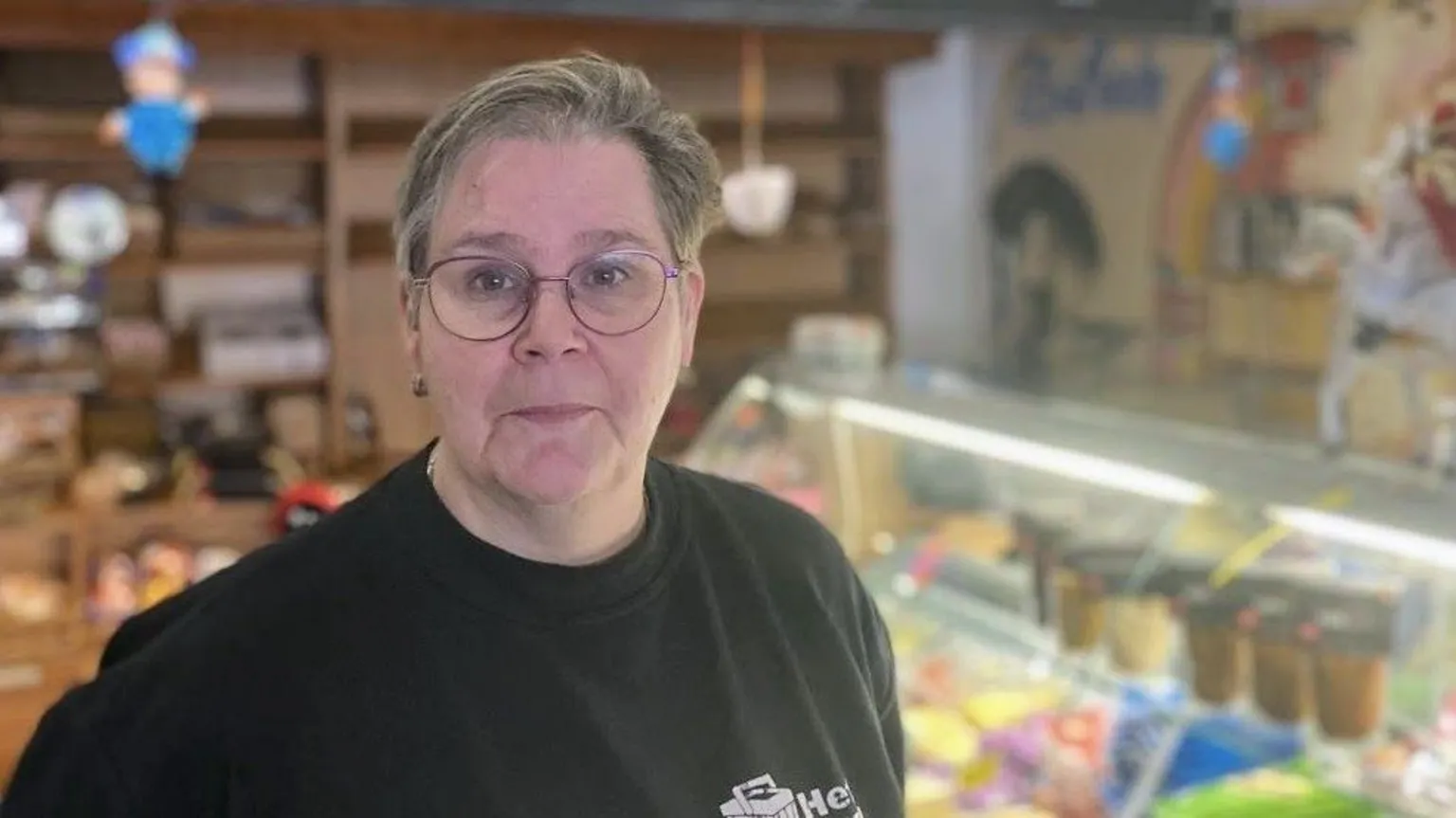 Andrea, the owner of the local grocery store, standing inside her shop