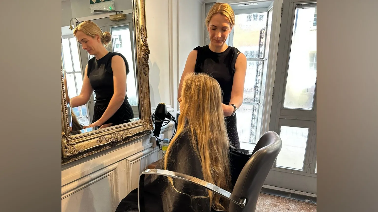 Alex Chapman Nine-year-old Noah sitting in a hairdressers as he prepares to get his long blond hair cut for charity. The hairdresser stands on his right hand side preparing to cut his hair.