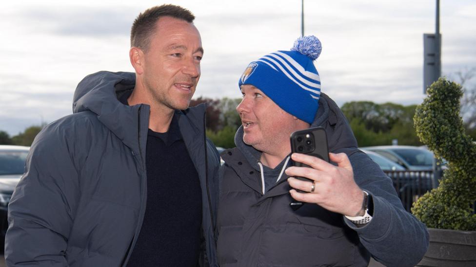 John Terry poses for a selfie with a Colchester fan outside their ground